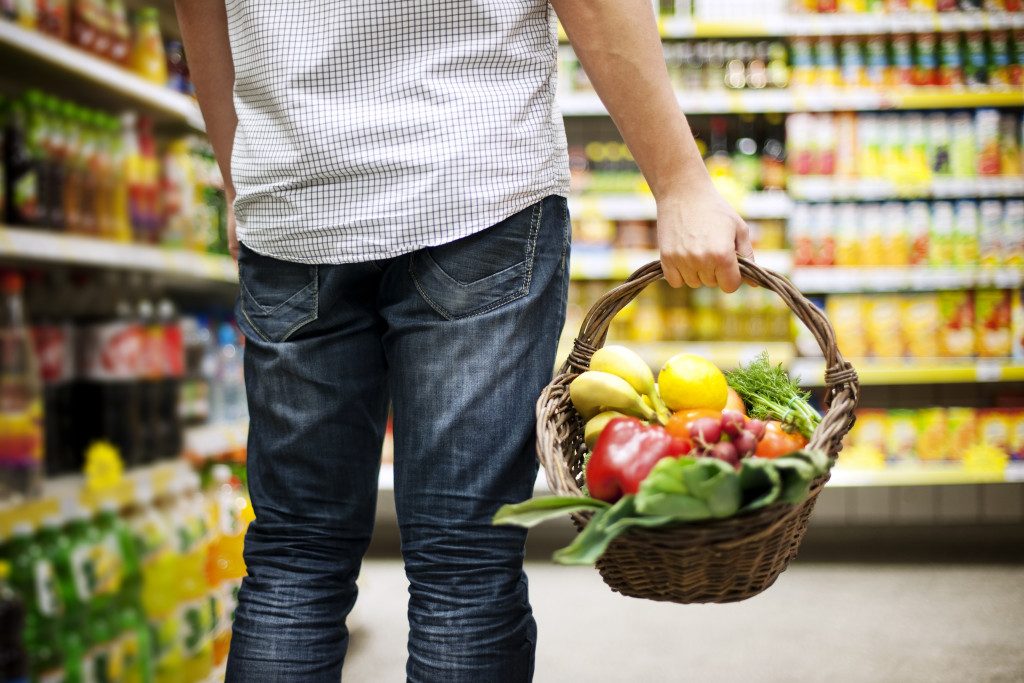 person holding a basket in the grocery store