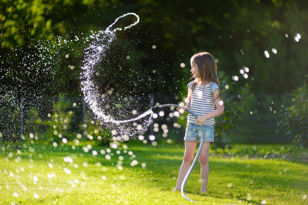 kid playing with garden hose