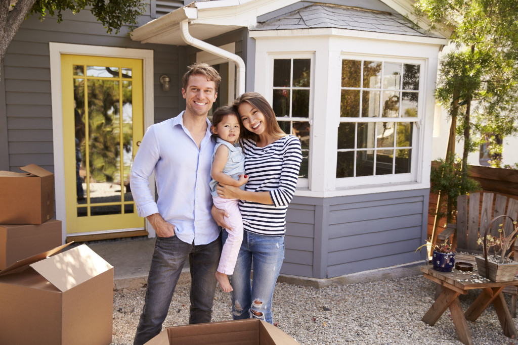 a smiling mother and gather in front of their new house