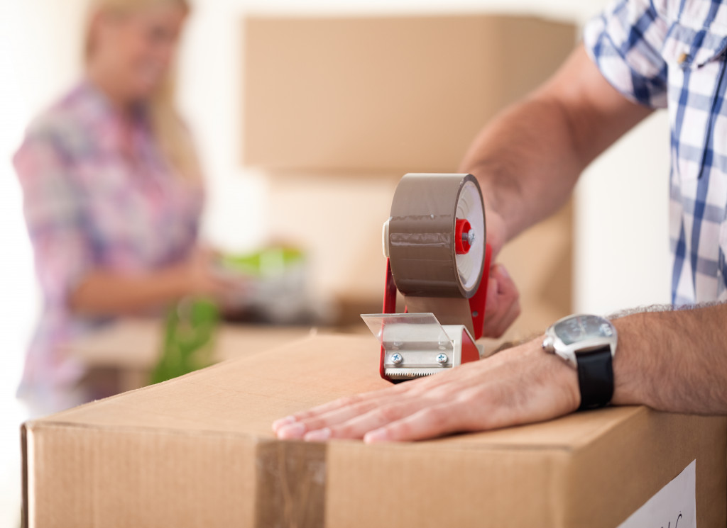 a person packing cardboard box