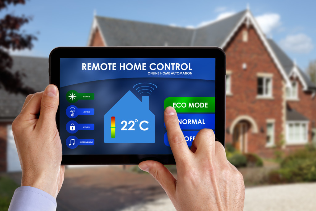 person using tablet to control his home from outside across the house