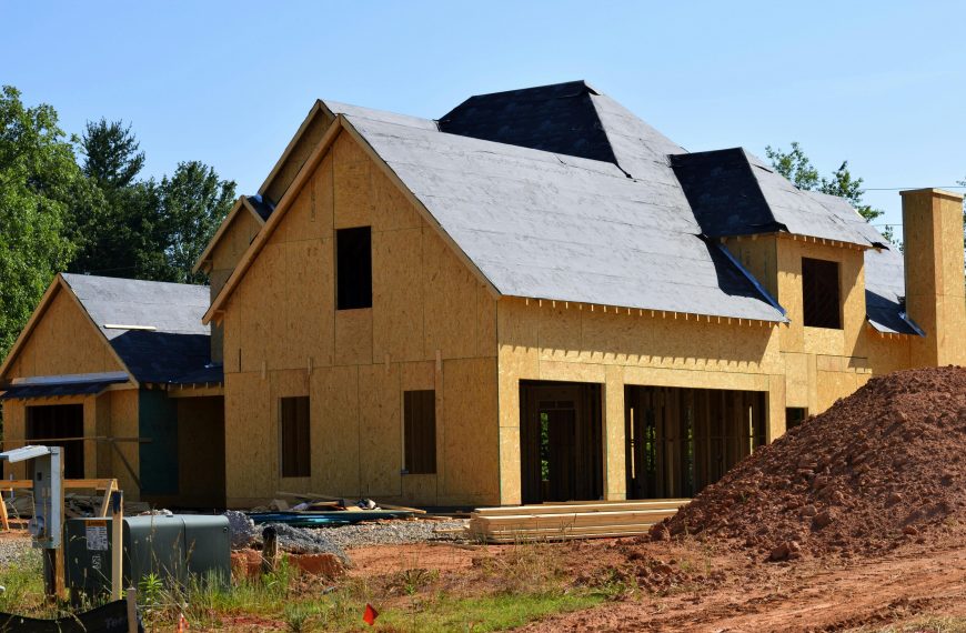 newly constructed home with a large mound of soil in the front yard
