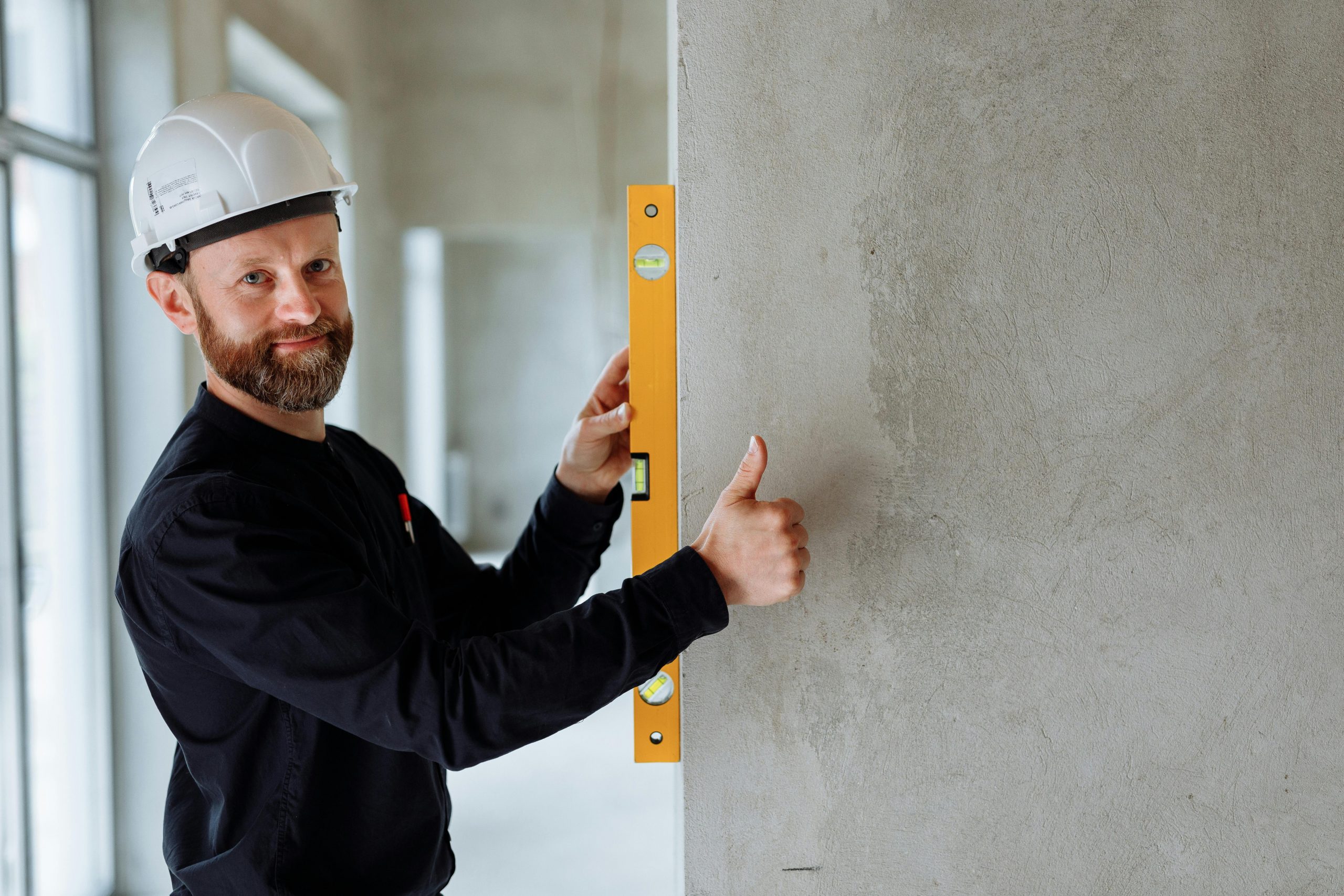 contractor wearing a white hard hat giving a thumbs up